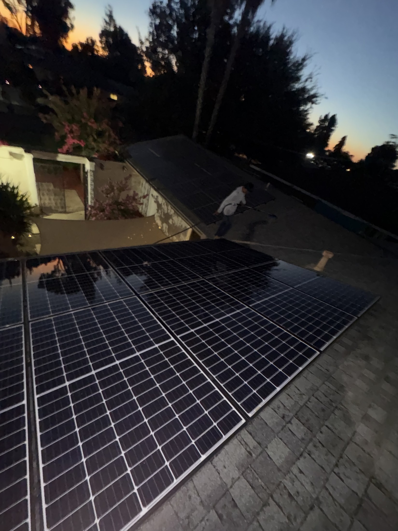 Rooftop solar panels cleaned to a flawless finish, glowing under a golden-hour sunset.